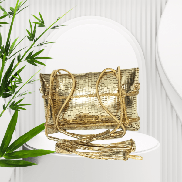 Stylish golden clutch with textured finish and rope detailing, displayed on a modern white setup with green leaves – available at Radofi Store.